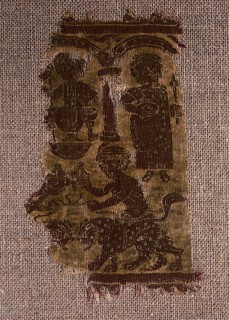 Tapestry fragment depicting a seated dignitary and a standing woman watching two youngsters leading panthers