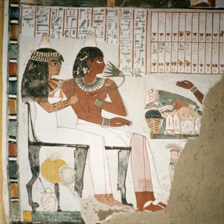 A detail of a wall painting in the tomb of Pere depicting the tomb owner and his wife before an altar laden with offerings