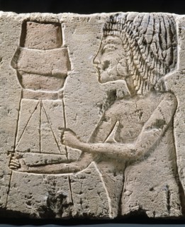 An Amarna relief showing a figure carrying an offering vessel