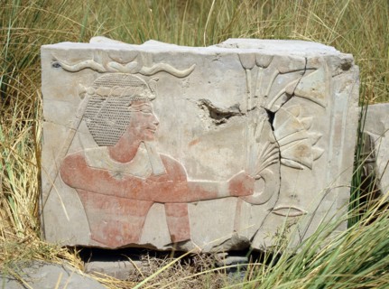 Block from a painted relief depicting a king with a rams horn headdress presenting an offering of flowers