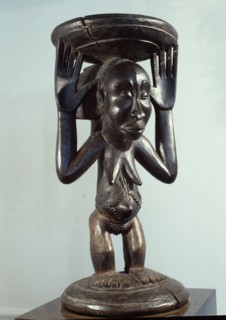 Stool or bowl supported by standing woman