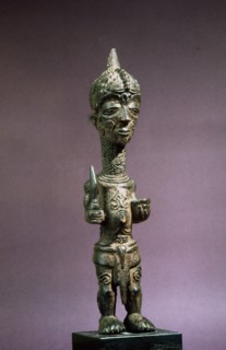 A male figure with elaborate scarification designs on his face and body