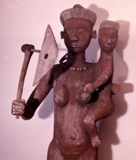 Large figure of a woman with the attributes of a chieftainess, used to surmount the roof of a chiefs hut