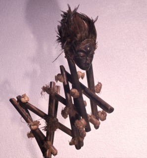 Western Pende divination instrument, Gulukoshi, which is held in diviners lap and springs forward when a wrongdoers name is mentioned