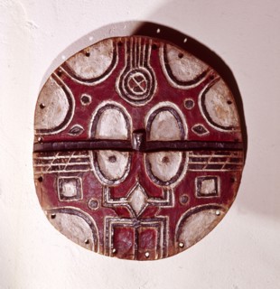 Circular mask used among the Tsaye in rituals of the Kidumu association, expressing social values through the abstract symbols taught to initiates