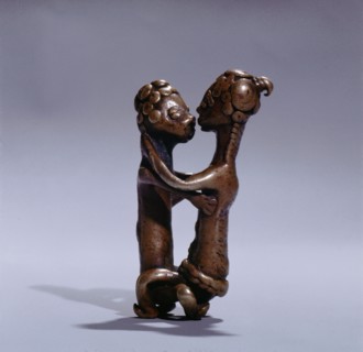 A gold weight representing a man and woman during sexual intercourse