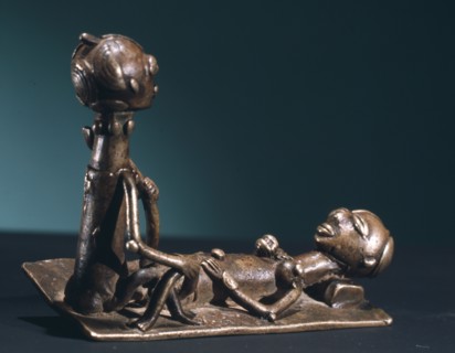 A brass weight which was used for weighing gold dust, representing a man and woman during sexual intercourse