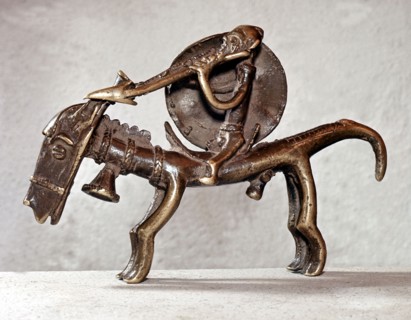 A brass weight for weighing gold dust in the form of a horse and rider carrying a spear and shield