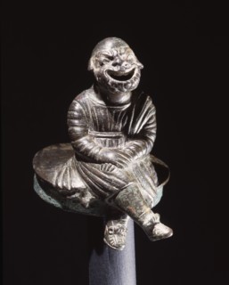 Bronze figure of a comic actor seated on a cylindrical lid, possibly from an incense burner