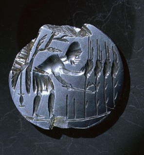 Intaglio amulet showing a reaper stooping to cut corn