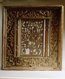 Wooden window panel from a temple, depicting a vase surrounded by cloud scrolls and the rising sun