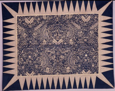 A batik kain depicting stylised wings, shrines and sacred mountains