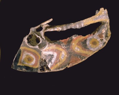 Asmat painted cassowary bone representing the dragon like head of the mythological giant cassowary