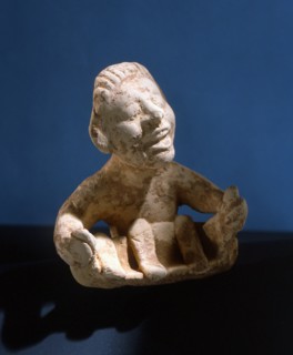 Terracotta figure of a man holding a model boat