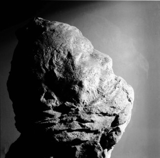 Cast of a mans head with his mouth partly covered with lava