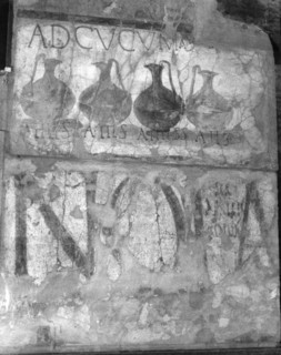 A wine shop sign in the main street, advising to come to the sign of the bowls (ad cucumas)