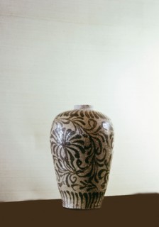 A vase decorated with a stylized pattern of leaves and flowers