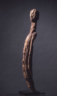 A wood sculpture of a man, possibly an ancestor figure