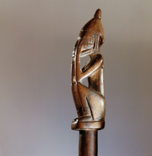 A divination tapper in the form of a miniature nommo figure in the so called shame position