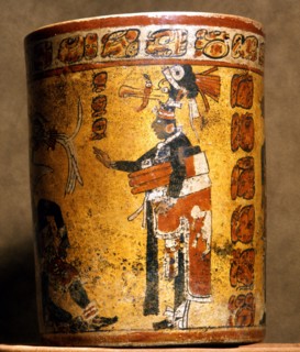 Cylindrical vessel decorated with date glyphs and a Mayan ball player wearing black body paint and heavy padding for the competition