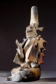 Seated Lord clasping a celt in his right hand