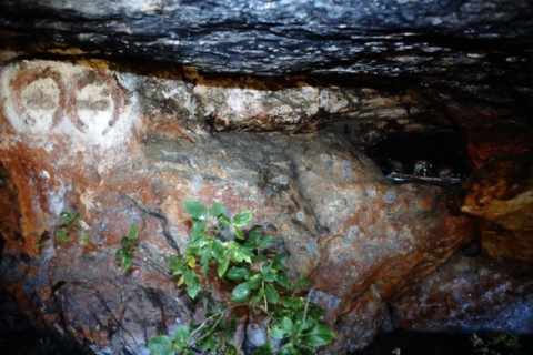 Aboriginal rock of two Wandjina Heads with a burial niche close by
