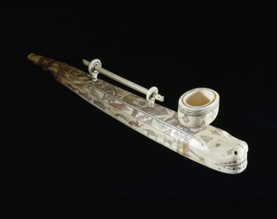 Elegantly carved and decorated pipe which carries its own cleaner in rings attached to the top