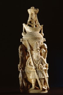 An ivory salt cellar around the base of which are figures of Portuguese noblemen