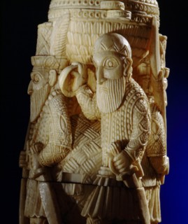 An ivory salt cellar around the base of which are figures of Portuguese noblemen
