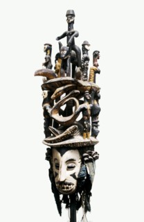 White faced Igbo mask with two tiered superstructure of polychromed figures, including a horse and rider and pythons