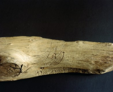 Three Viking ship prows incised on a piece of wood