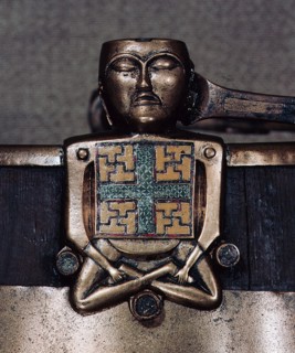 A figure of Hiberno Saxon origin on the handle of a bucket with swastika symbols of Thor