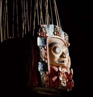Frontlet with a human figure surrounded by seven smaller figures interspersed with abalone shell