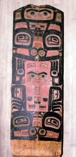 A carved and painted cedar board with a design showing ancestry and social position
