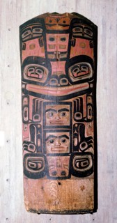 A carved and painted cedar board with a design showing ancestry and social position