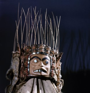 Chiefs headdress with humanoid face surrounded by a row of abalone shell and a double row of smaller faces