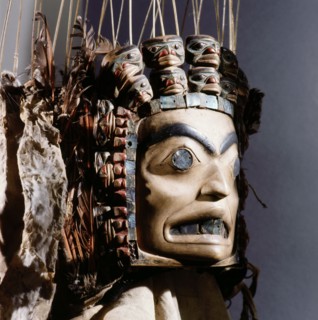 Chiefs headdress with humanoid face surrounded by a row of abalone shell and a double row of smaller faces