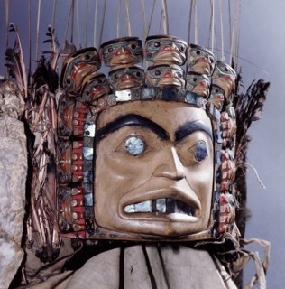 Chiefs headdress with humanoid face surrounded by a row of abalone shell and a double row of smaller faces