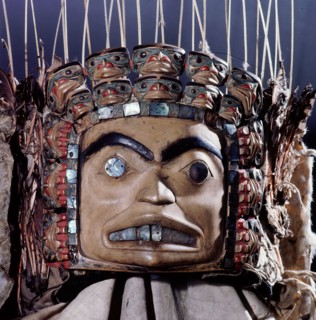 Chiefs headdress with humanoid face surrounded by a row of abalone shell and a double row of smaller faces