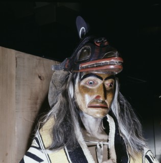 Carved and painted figure of a shaman wearing ritual robes and a headdress