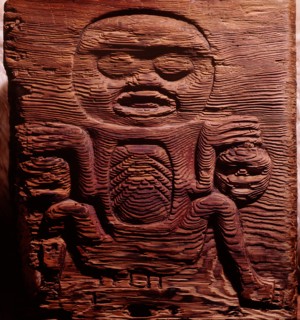 A cedar box carved in relief with a shaman displaying human heads
