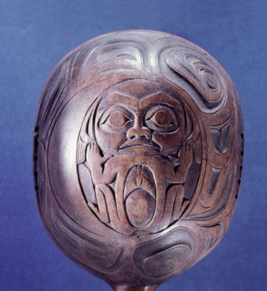 An unpainted shamans rattle carved in low relief