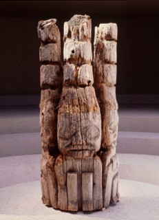 The top section of a Haida house frontal pole depicting three watchmen