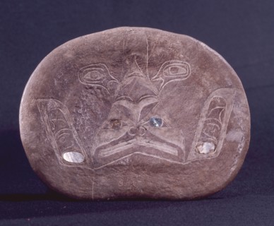 An incised drawing of a dogfish on a section of bone with inlaid abalone shell