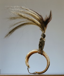 A warriors chest ornament with a seated figure on a boar tusk