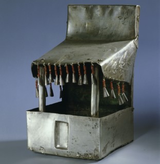 A model temple made of beaten silver, with bell like tassels hanging from the roof