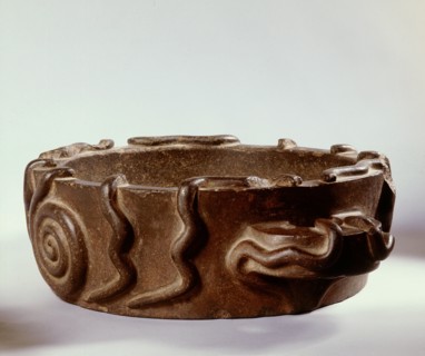A dish of monumental style decorated with serpents