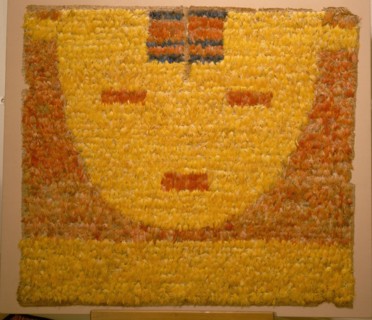 Featherwork tabbard depicting a serene sun face, or sun in repose, the personification of the sun god Inti