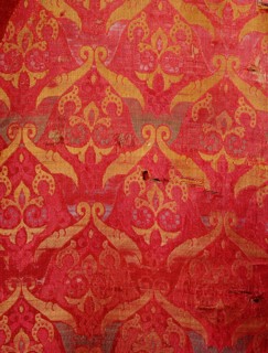 A detail of a red and gold silk weaving from Granada