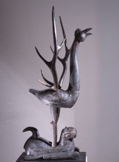 Sculpture of a phoenix with spread wings in the form of deer antlers, resting on a reclining tiger